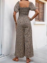 Taupe floral smocked bodice jumpsuit with puff sleeves and wide legs.