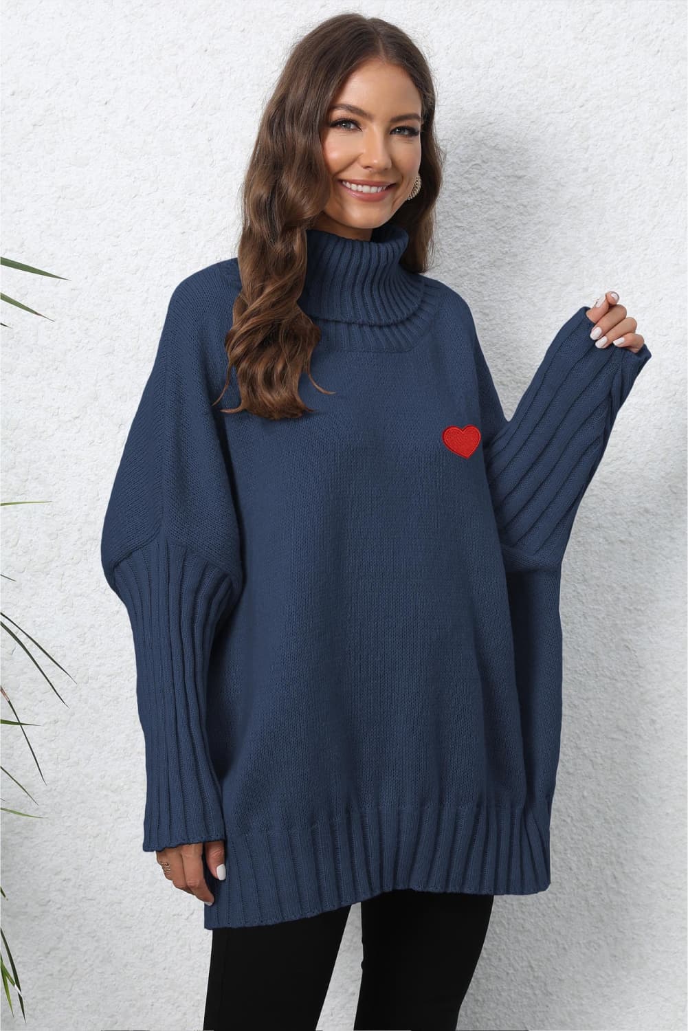Dark Blue batwing knit turtleneck sweater with red heart embroidery and ribbed sleeves.
