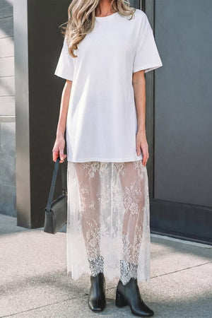 White cotton t-shirt dress with sheer lace midi skirt and lace trim on boots.