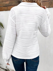 White textured quarter zip pullover with a collared neckline and long sleeves.