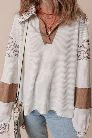 White waffle knit polo with leopard print patches and brown accents.