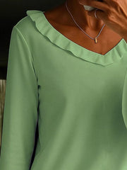 Green polyester v-neck blouse with ruffled neckline and long sleeves.