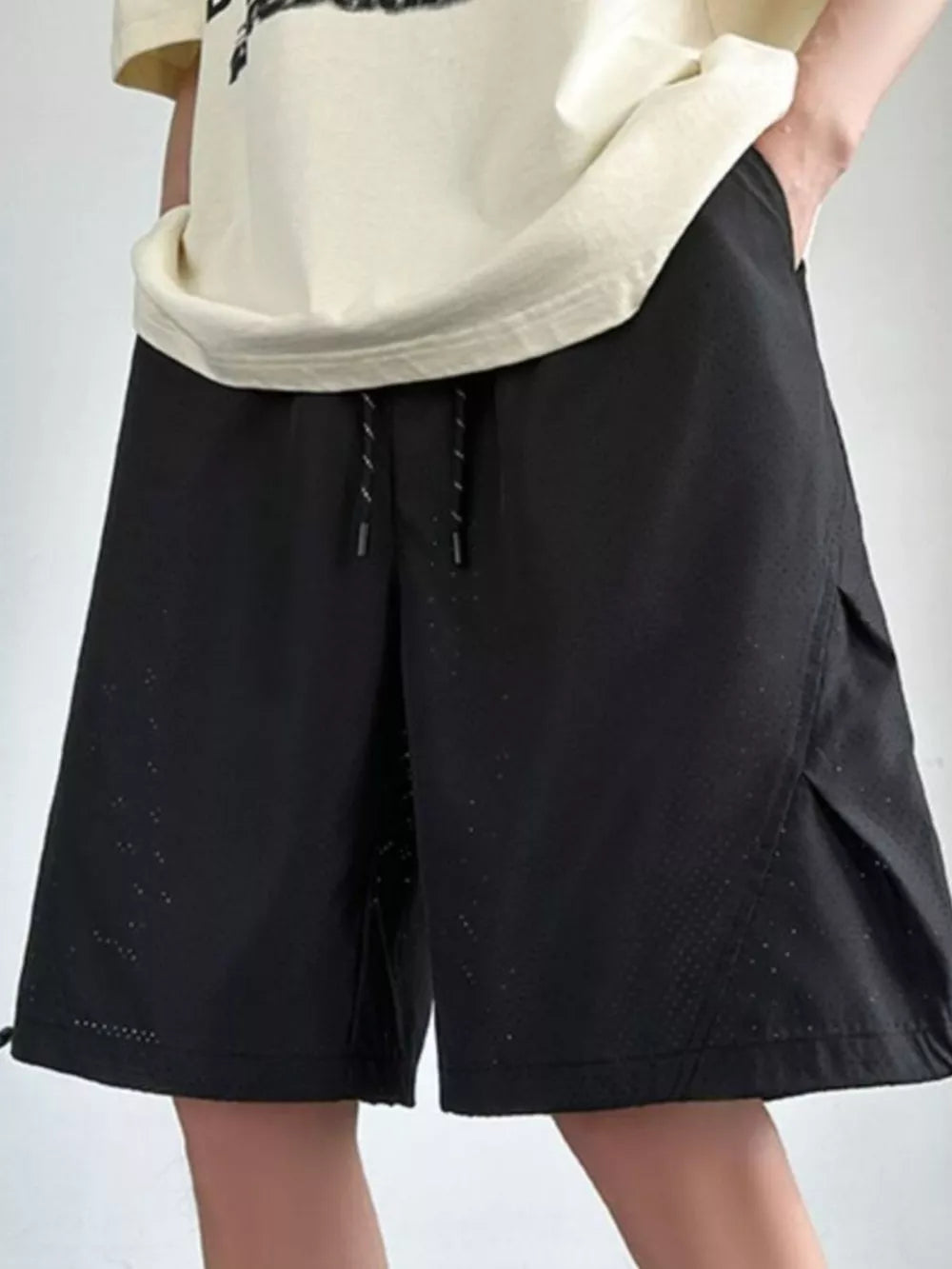 Black chino shorts with drawstring waist and perforated detail.