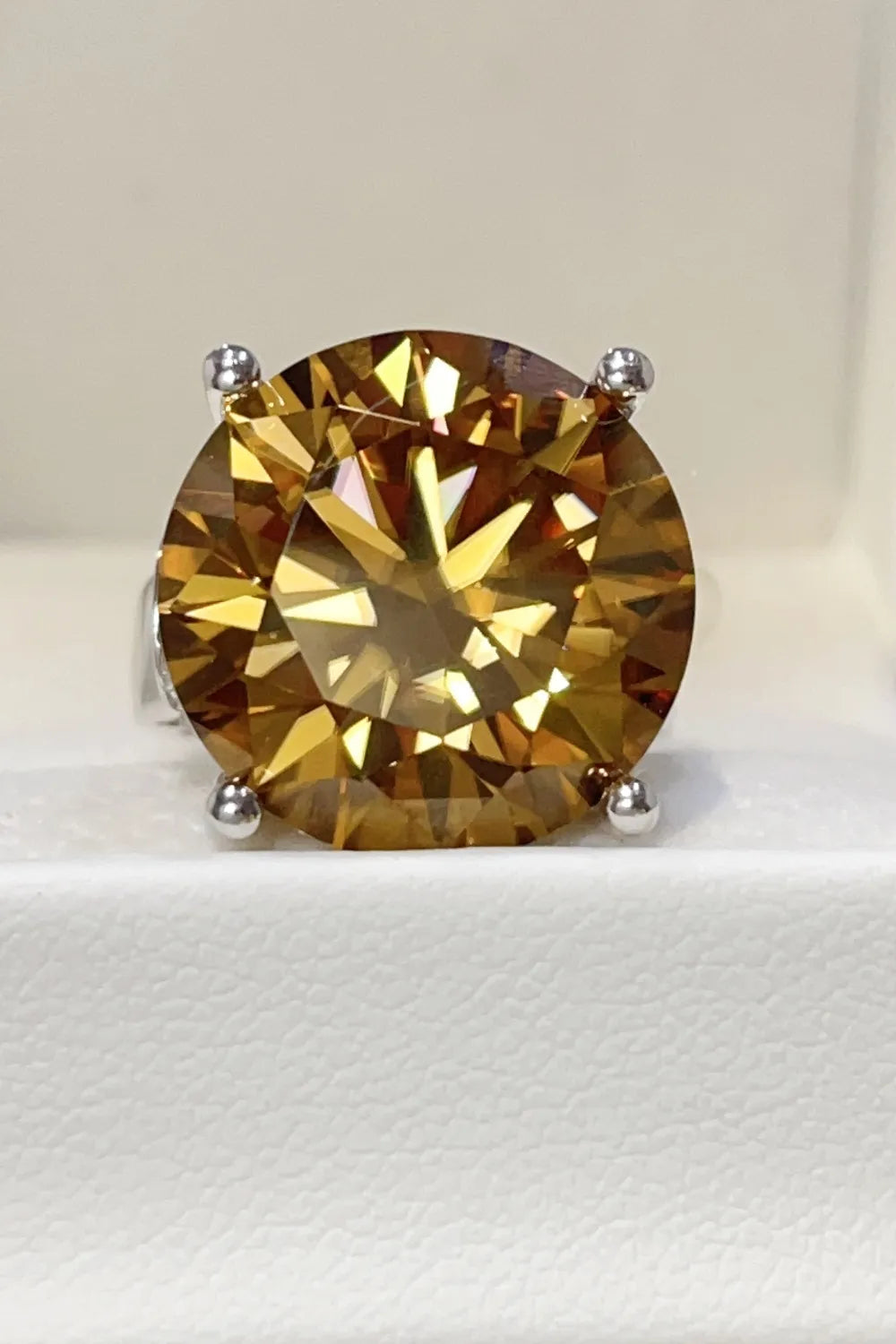 Gold cocktail ring with a large radiant cut moissanite gemstone.