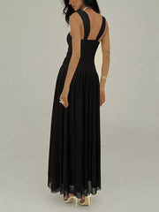 Black ruched sleeveless maxi dress with a-line skirt and embellishments.