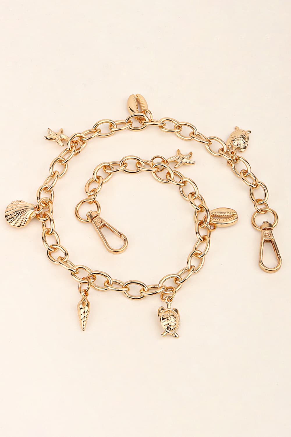 Gold chain belt with seashell, starfish, turtle, and conch charms and lobster clasps.
