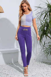 Electric purple skinny trousers with chain detail at the waist.
