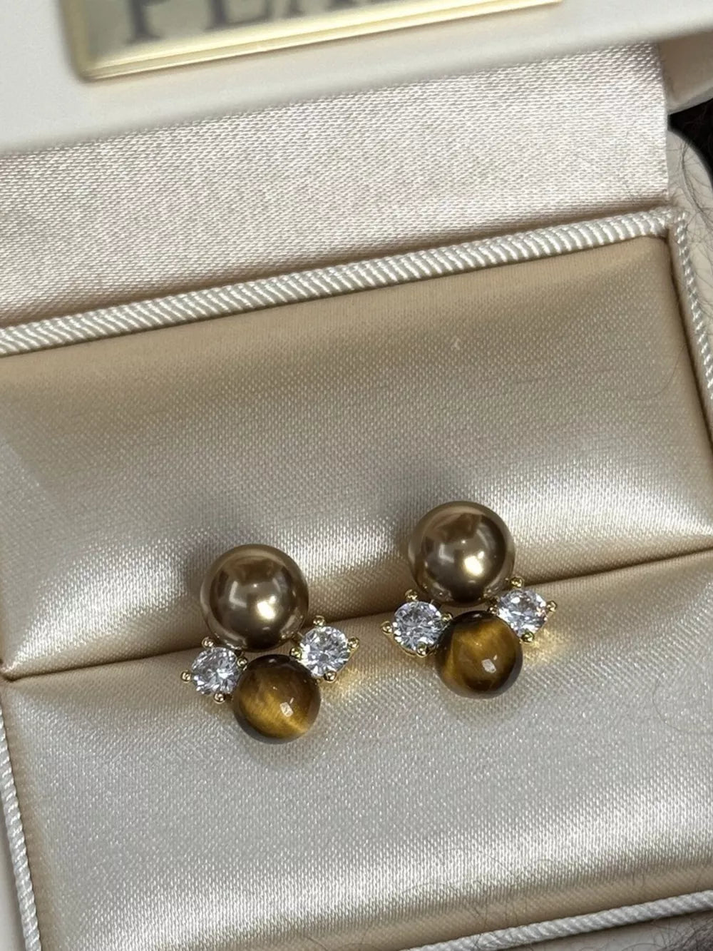 Spherical tiger eye stone stud earrings with clear accents and gold pearls