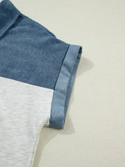 Two-tone denim polo shirt with cuffed sleeves and color-block design.