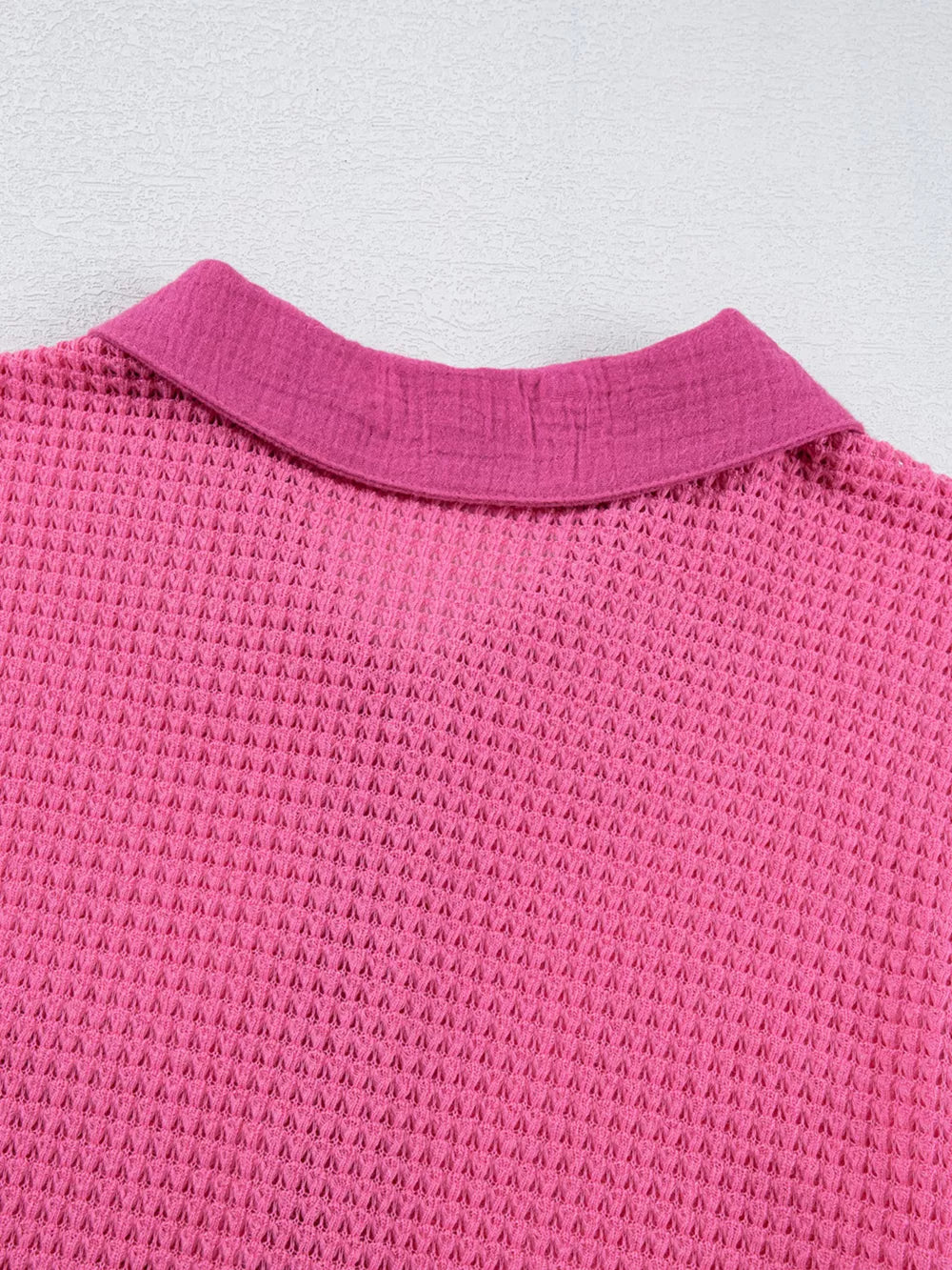 Waffle-knit button-down shirt in cerise pink with a collared neckline.