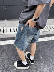 Men's relaxed fit blue denim shorts with a vintage wash and distressed details.