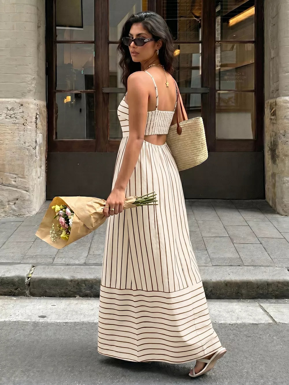 Patterned cutout maxi dress with smocked detail in apricot and brown stripes.