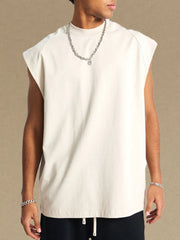 Raglan shoulder sleeveless top in beige with a mock neckline, styled with a silver chain necklace.