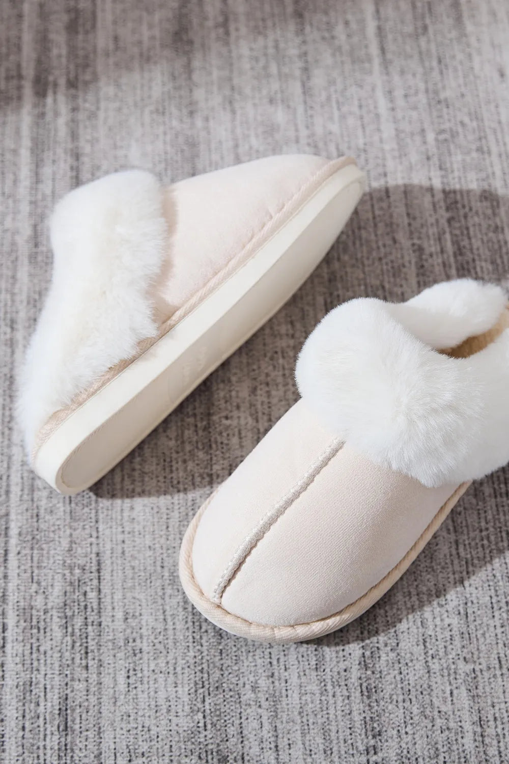 Beige suede house slides with white shearling trim detail.