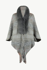 Textured knit cape with faux fur collar and fringe detail.