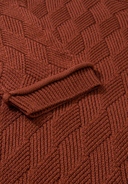 Textured diamond knit sweater in rust acrylic with ribbed cuff detail.