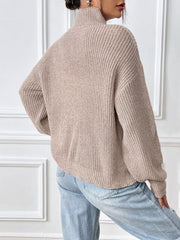 Relaxed fit beige ribbed knit turtleneck sweater with balloon sleeves.