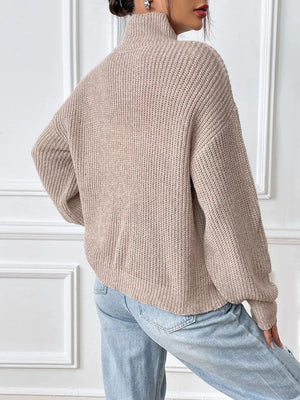 Relaxed fit beige ribbed knit turtleneck sweater with balloon sleeves.
