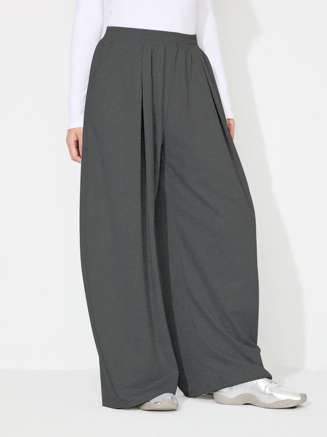 Dark gray pleated drape palazzo trousers with a wide leg and elastic waistband.