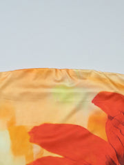 Strapless tube top with abstract floral print in orange and yellow hues.