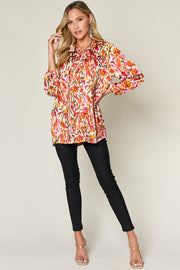 Silk ikat tie-neck blouse in multicolor abstract print with button closure and 3/4 sleeves.