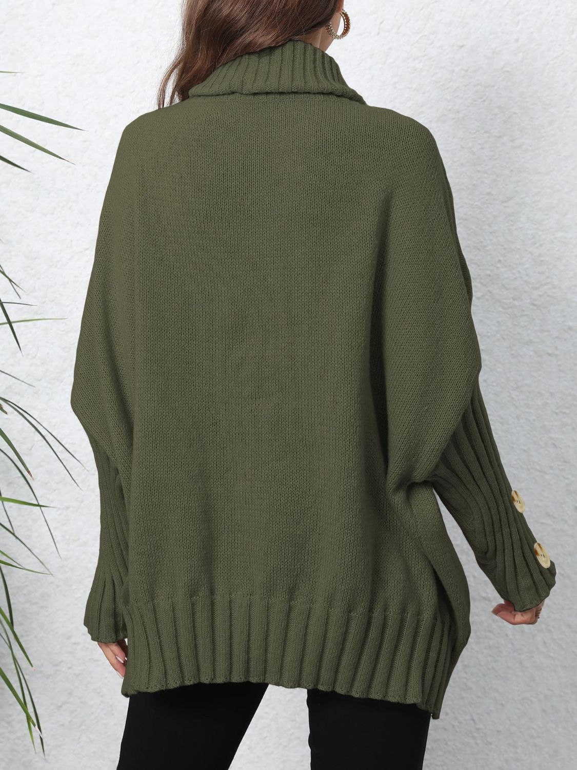 Button-cuff turtleneck slouchy knit sweater in green with ribbed details and button accents on the sleeves.