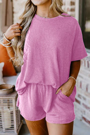 Pink waffle knit lounge set with short sleeves and shorts, featuring pockets.