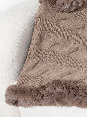 Mocha cable knit poncho with faux fur trim and textured knit detail.