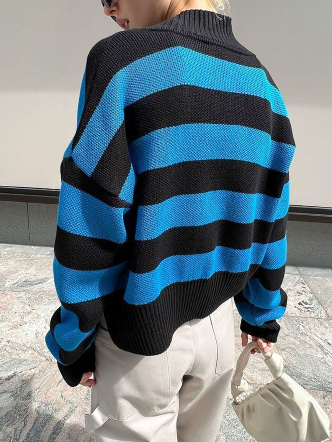 Cropped acrylic knit cardigan with black and blue stripes and a mock neck.