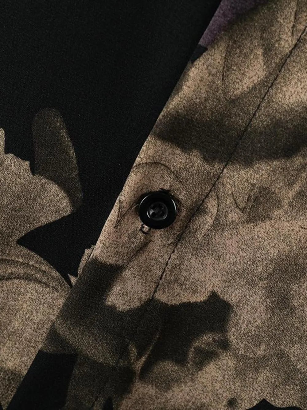 Men's oversized floral print shirt in tan and black cotton, showing button detail.