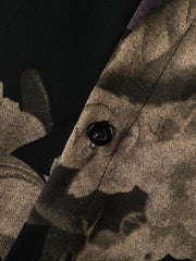Men's oversized floral print shirt in tan and black cotton, showing button detail.