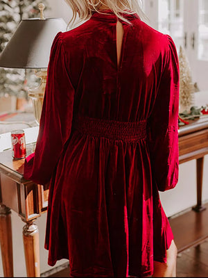 Burgundy velvet mock neck dress with balloon sleeves and smocked waist.