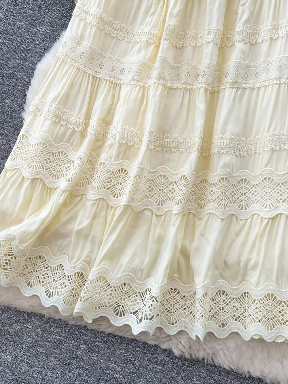 Apricot tiered maxi skirt with intricate lace trim and eyelet details.