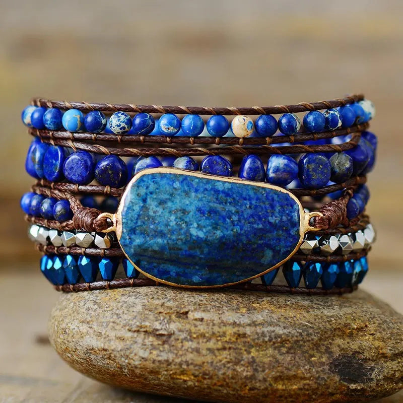 Bohemian wrap bracelet with blue stones and beads on brown cord, featuring a large central stone.