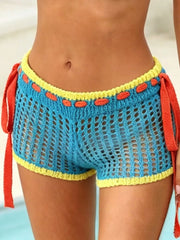 Teal crochet shorts with yellow trim and orange detail, featuring tie sides.
