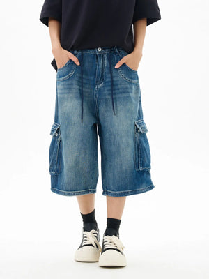 Relaxed fit vintage blue denim cargo shorts with drawstring waist and utility pockets.
