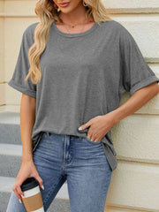 Gray relaxed fit t-shirt with rolled sleeves and crew neck, styled with jeans.