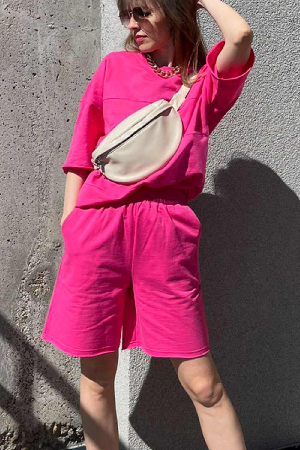 Relaxed pink sweatshirt and shorts set with seam details and pockets.