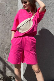 Relaxed pink sweatshirt and shorts set with seam details and pockets.