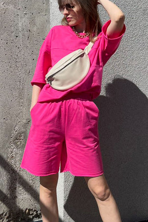 Relaxed pink sweatshirt and shorts set with seam details and pockets.