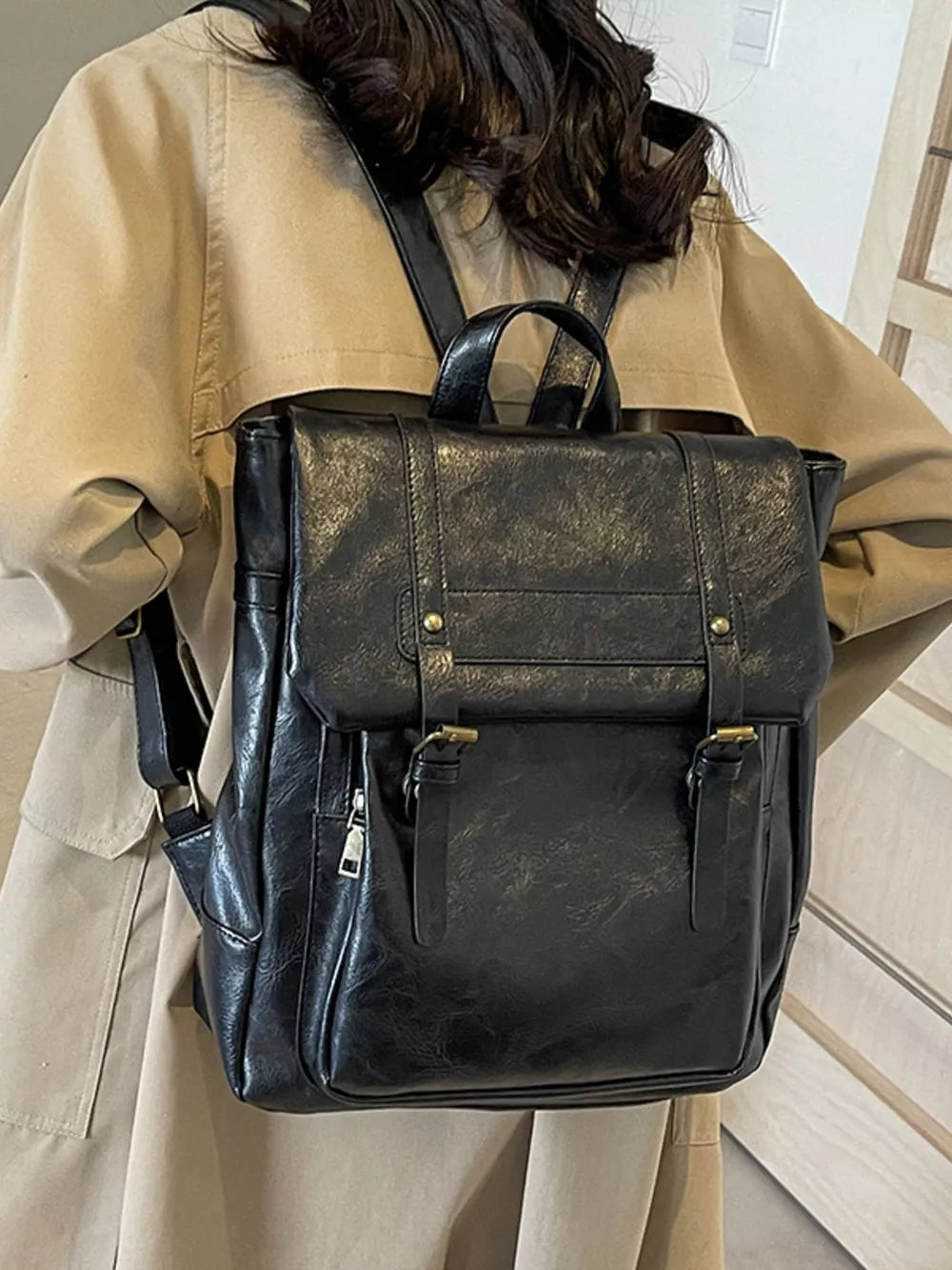 Black pu leather flap backpack with brass hardware and adjustable straps