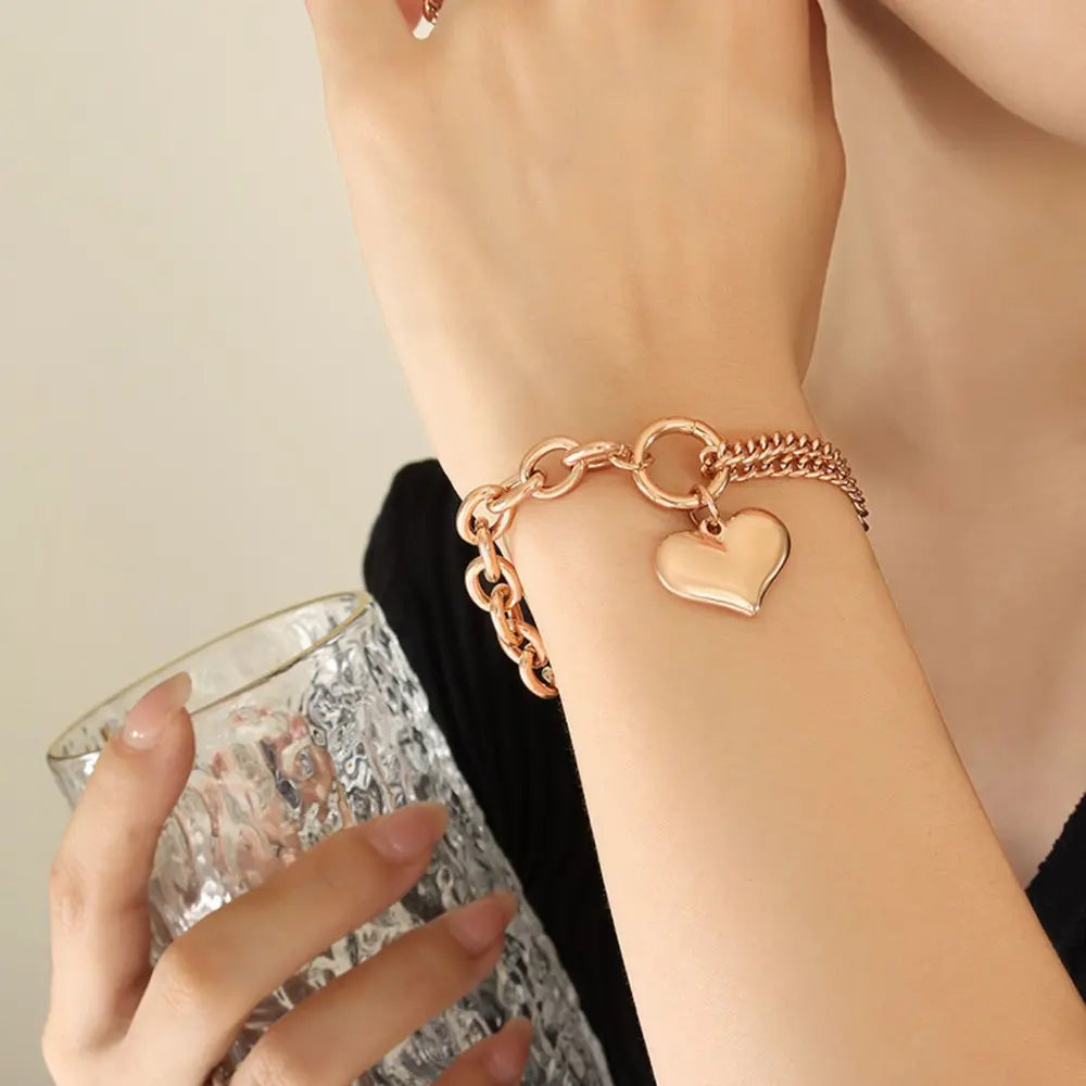 Rose gold heart charm bracelet with chunky chain detail.