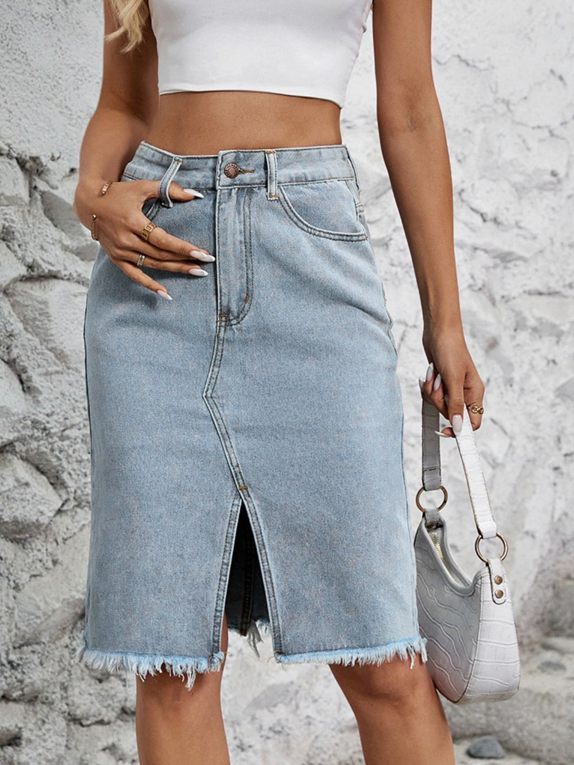Light blue denim pencil skirt with front slit and frayed hem.
