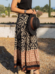 Tiered maxi skirt with black and beige medallion print and a ruffled hem.