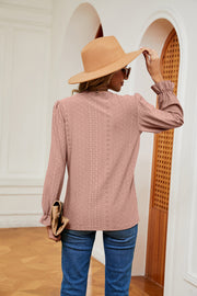 Dusty pink perforated blouse with ruffle cuffs and long sleeves.