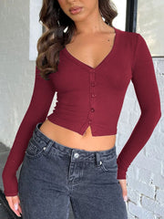 Burgundy ribbed V-neck crop top with buttons and long sleeves.