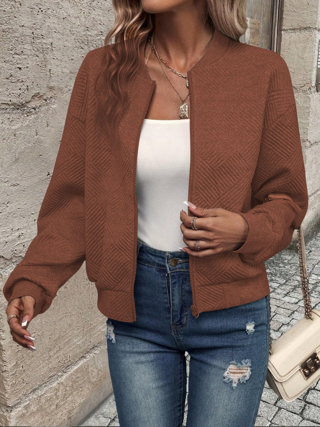 Caramel geometric quilted bomber jacket with a round neckline and zipper closure.