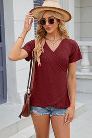 Burgundy eyelet wrap v-neck top with short sleeves and a textured pattern.