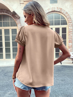 Camel gathered sleeve blouse with a relaxed fit, styled with denim shorts.
