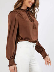 Brown satin blouse with tie-neck, ruffled collar, and shirred cuffs.